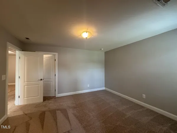 an empty room with closet and windows