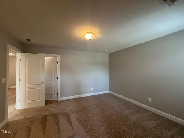 an empty room with closet and windows