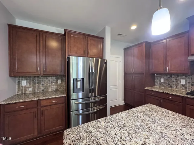 a kitchen with a refrigerator sink and cabinets