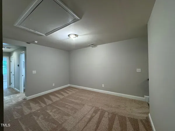 an empty room with a fan & a window