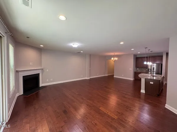 a view of a big room with wooden floor fireplace and windows
