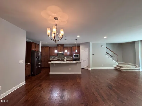 a view of a living room and kitchen with wooden floor
