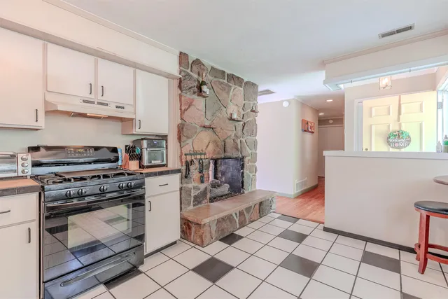 a kitchen with a sink a stove cabinets and a dining table