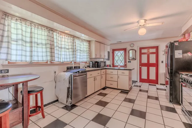 a large kitchen with a stove a sink dishwasher a refrigerator and cabinets with wooden floor