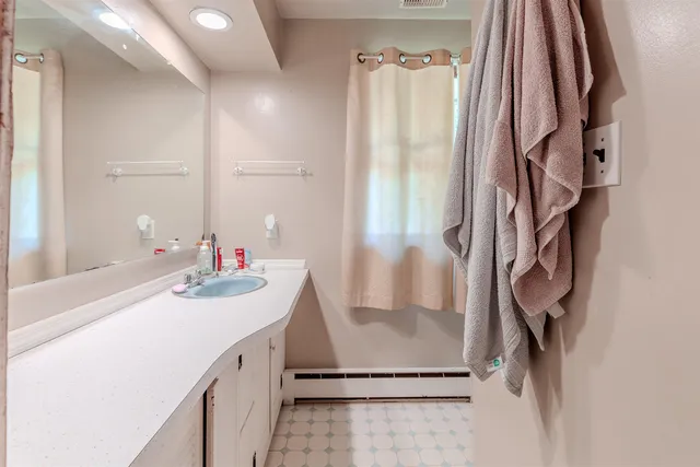 a bedroom with a bed and a flat tv screen on the dresser