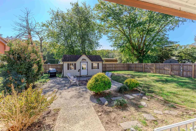 a view of a house with backyard sitting area and garden