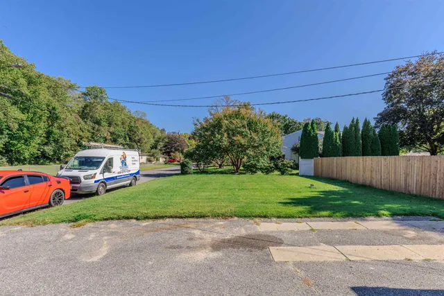 a front view of a house with a yard and trees