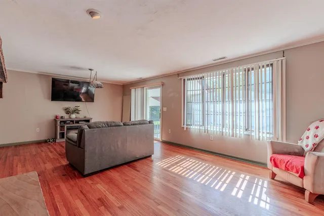 a living room with furniture a flat screen tv and a large window