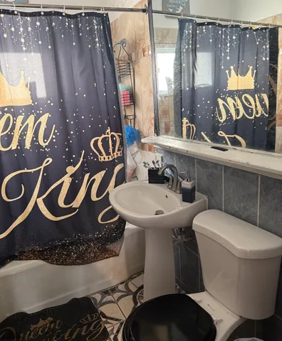 a bathroom with a toilet sink and mirror