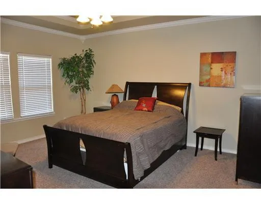 a bedroom with a bed and a potted plant