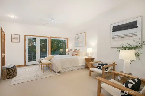 a spacious bedroom with a large bed and a chandelier