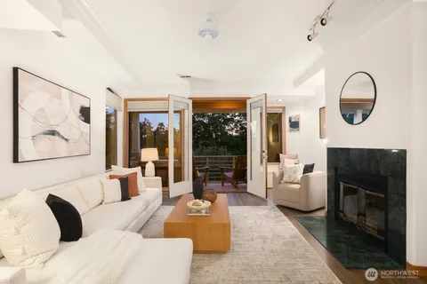 a living room with furniture a fireplace and a large window