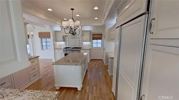 a view of a kitchen with kitchen island stainless steel appliances refrigerator stove microwave and cabinets