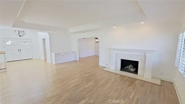 a view of empty room with wooden floor and fireplace
