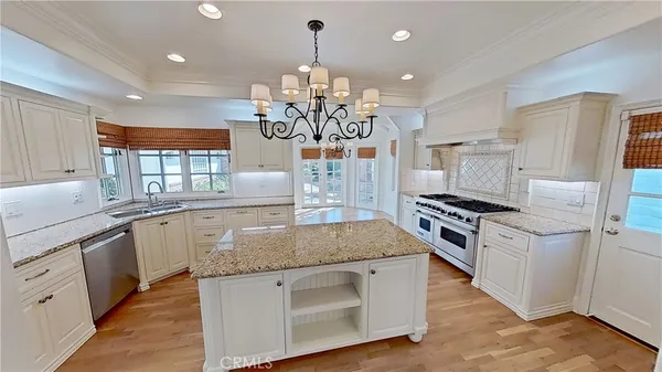 a kitchen with stainless steel appliances granite countertop a sink dishwasher a refrigerator and a stove