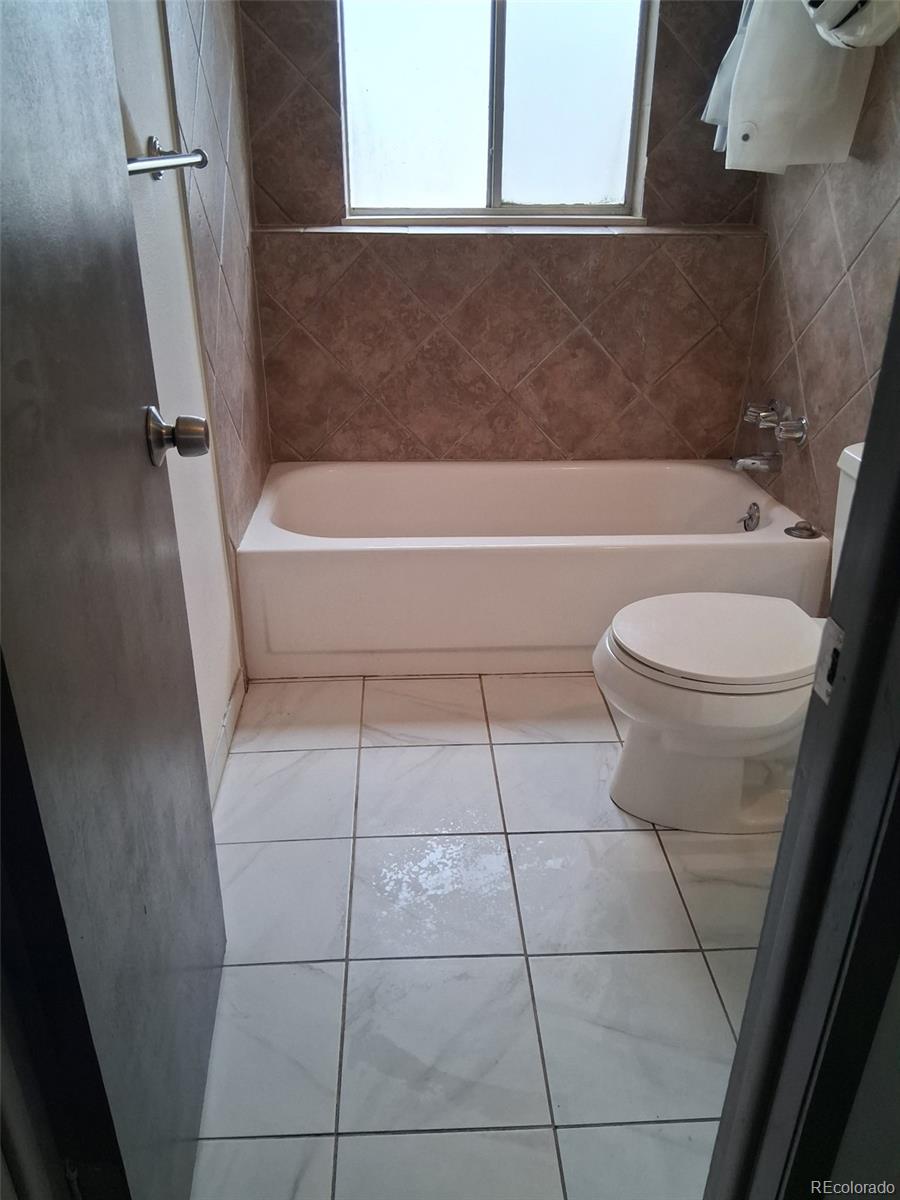 9162 Cody Street Broomfield, CO 80021 - Photo 13 of 29 a bathroom with a toilet a sink and bathtub