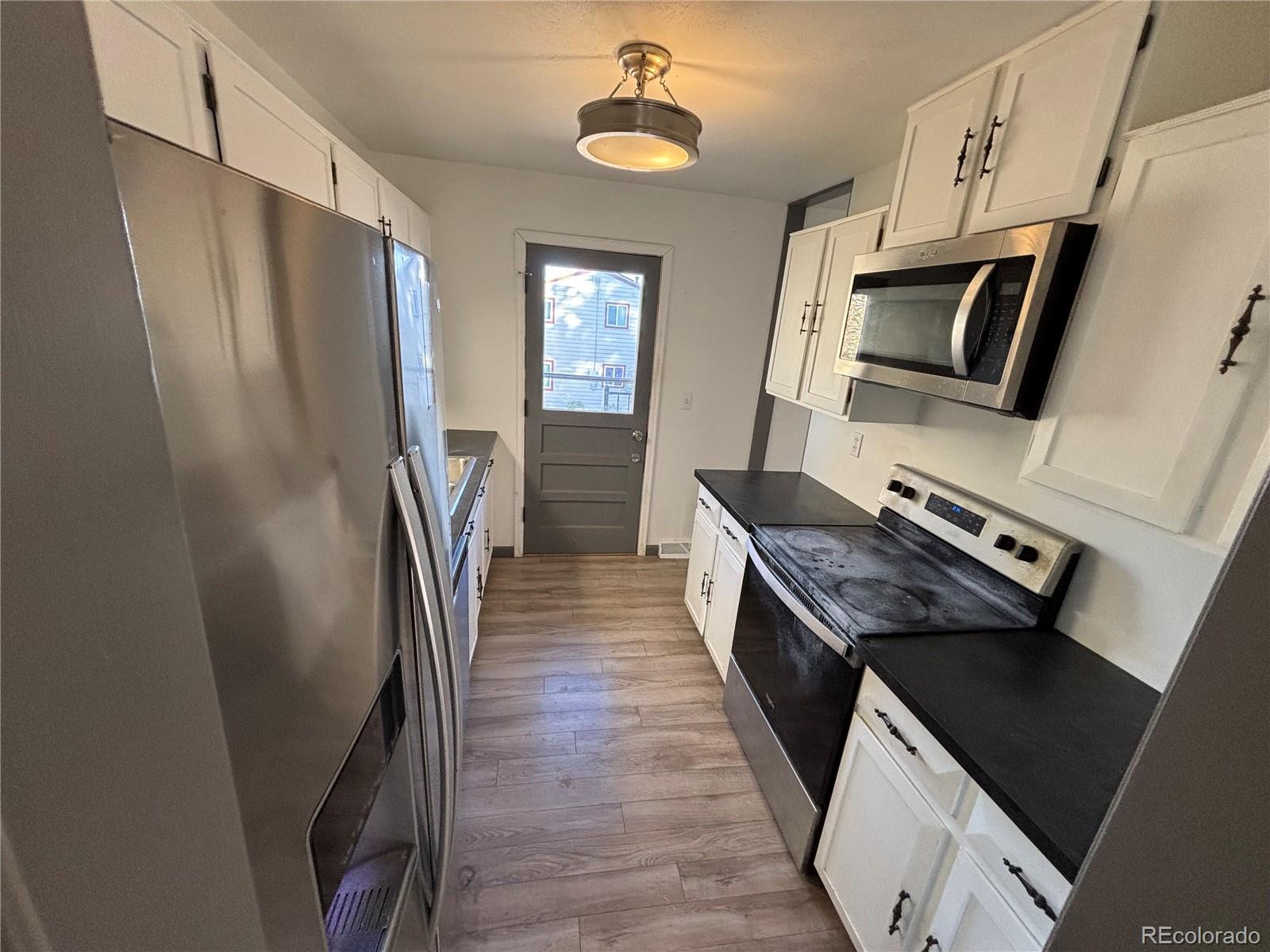 9162 Cody Street Broomfield, CO 80021 - Photo 3 of 29 a kitchen with stainless steel appliances granite countertop a refrigerator a stove and a sink