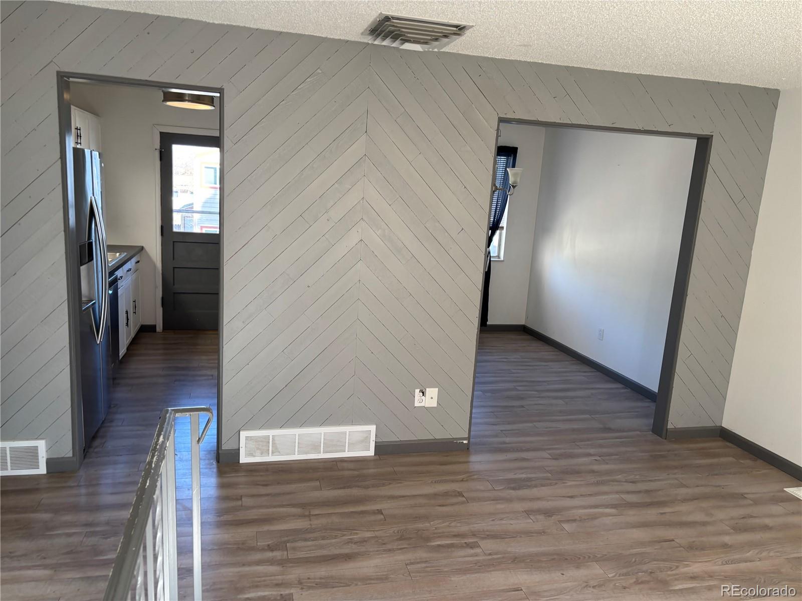 9162 Cody Street Broomfield, CO 80021 - Photo 4 of 29 a view of a hallway with wooden floor and staircase