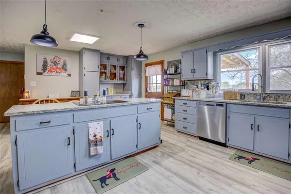 a kitchen with kitchen island granite countertop a sink cabinets and window