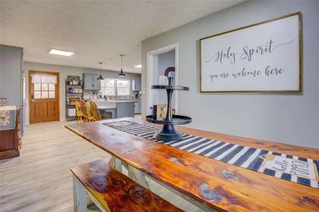a view of a dining room with furniture a chandelier and wooden floor