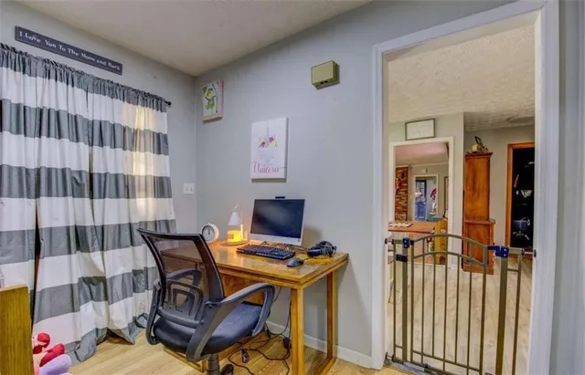 a view of a workspace with furniture and a window