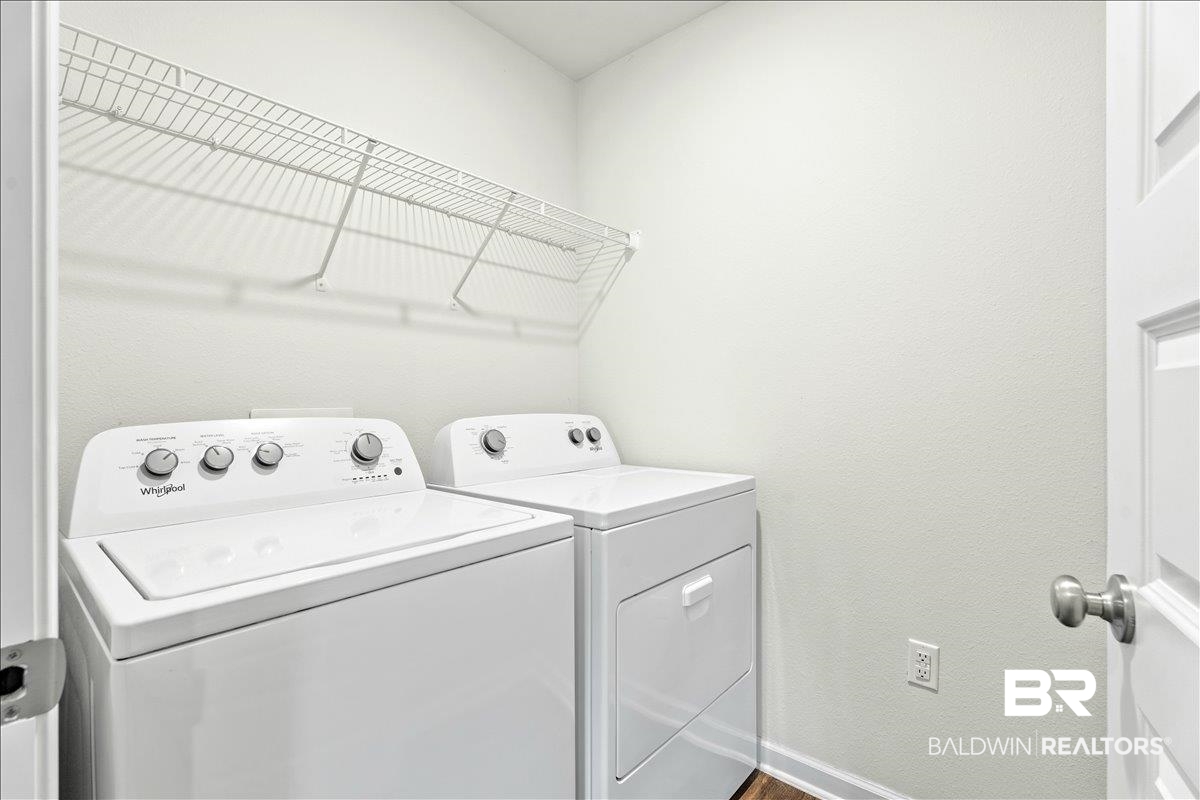 23641 Unbridled Loop Daphne, AL 36526 - Photo 26 of 40 Laundry area featuring white walls, wire shelving, and wood-finish flooring