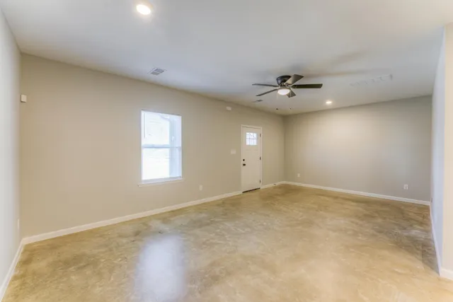 an empty room with a window and a ceiling fan