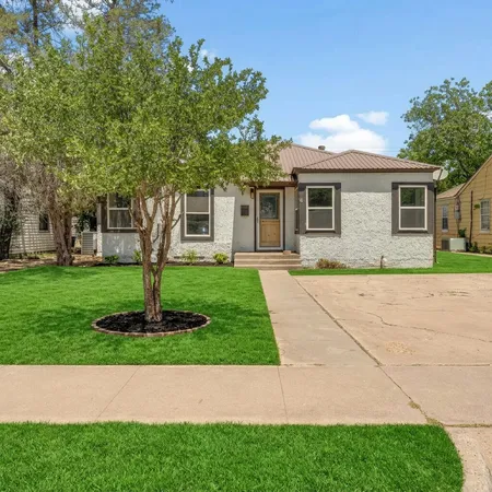 a front view of house with yard and green space