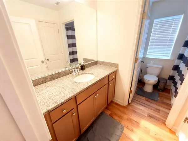 a bathroom with a granite countertop sink and a mirror