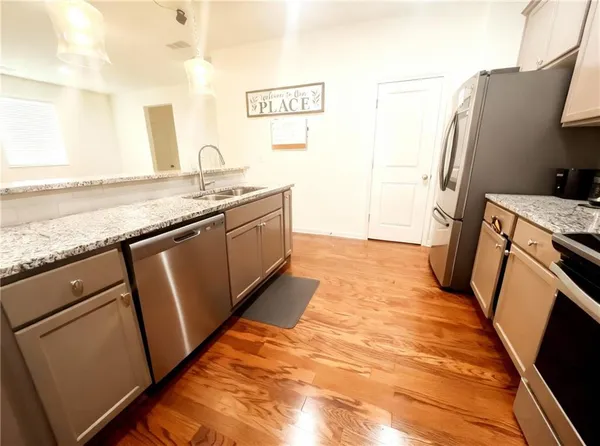 a kitchen with stainless steel appliances granite countertop a sink stove and refrigerator