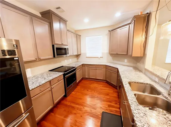 a kitchen with stainless steel appliances kitchen island granite countertop a stove and a microwave