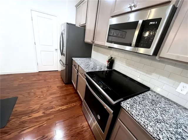a close view of a sink and dishwasher with wooden floor