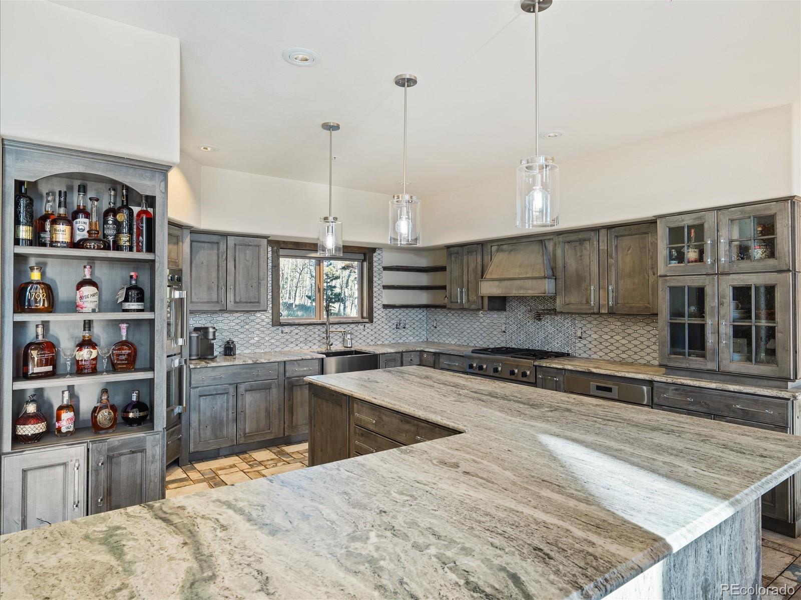 479 Dakota Ridge Road Idaho Springs, CO 80452 - Photo 11 of 50 a large kitchen with kitchen island a stove a sink a center island and living room view