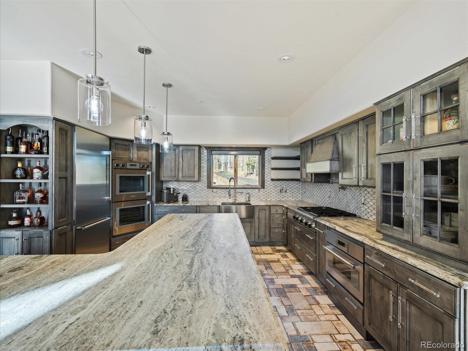 479 Dakota Ridge Road Idaho Springs, CO 80452 - Photo 12 of 50 a large kitchen with stainless steel appliances granite countertop a refrigerator and a stove top oven