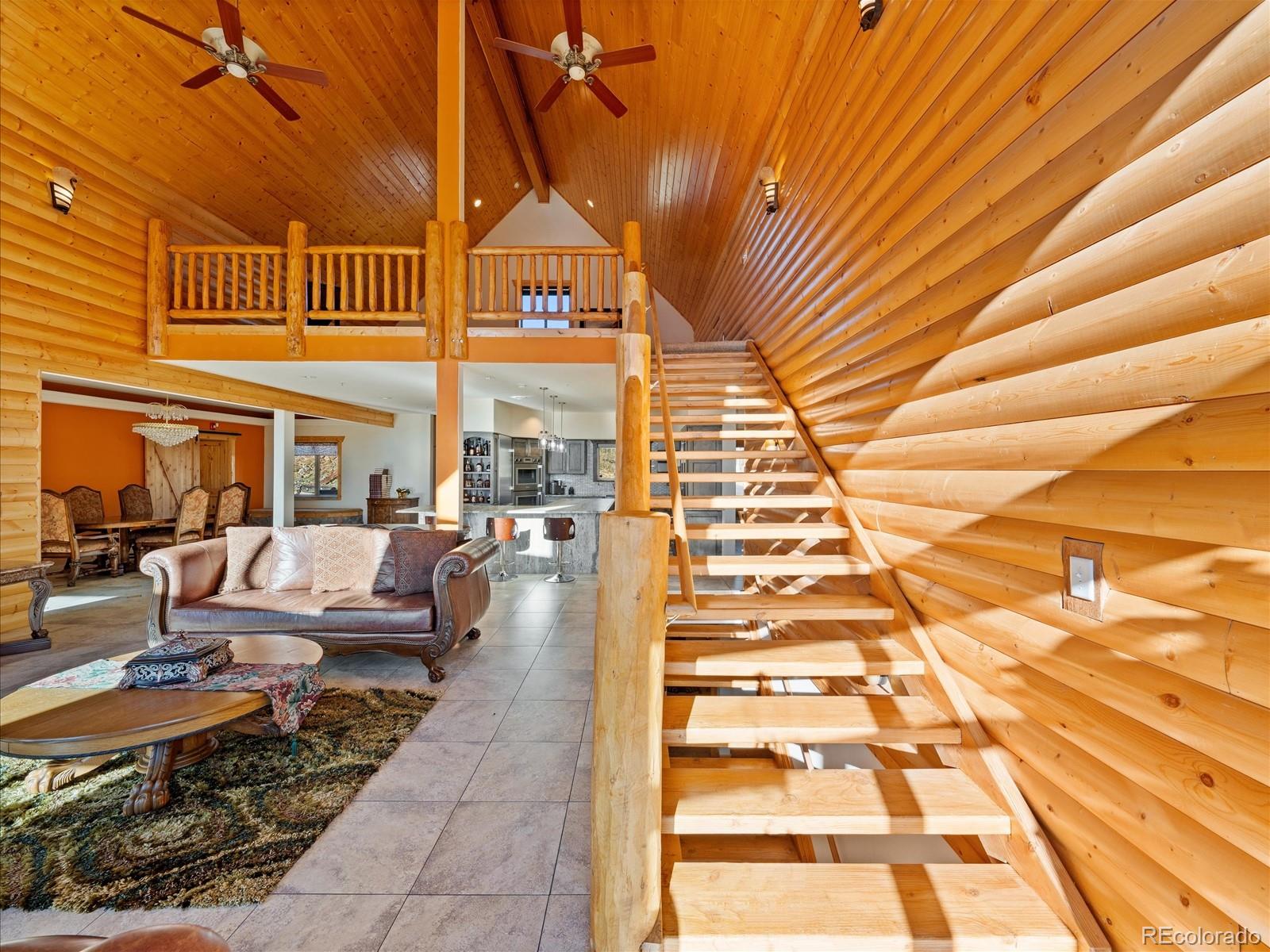 479 Dakota Ridge Road Idaho Springs, CO 80452 - Photo 16 of 50 a view of a patio with couches table and chairs with wooden floor