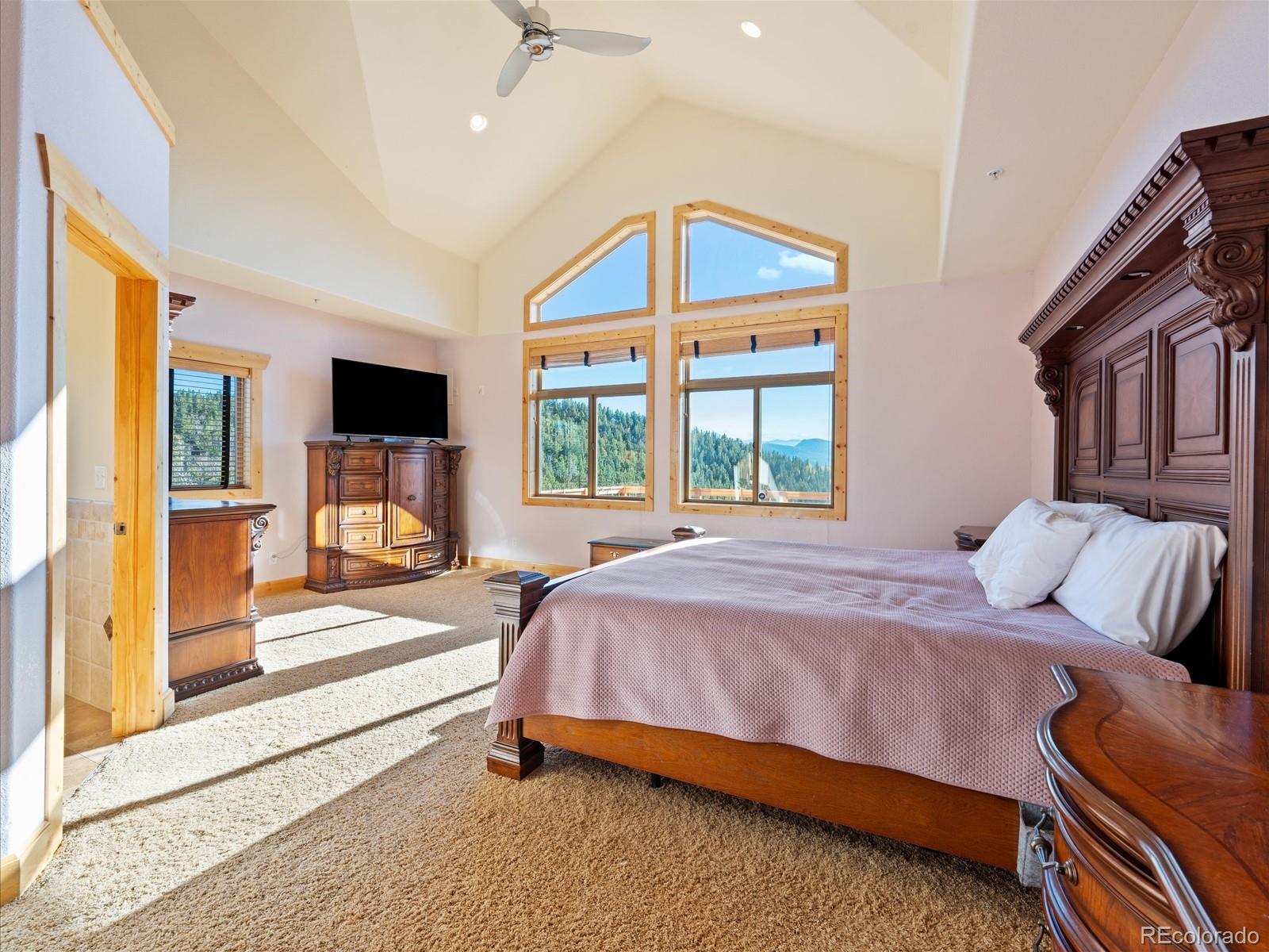 479 Dakota Ridge Road Idaho Springs, CO 80452 - Photo 17 of 50 a bedroom with a bed wooden floor and flat screen tv