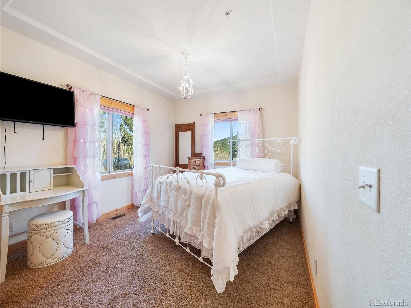 479 Dakota Ridge Road Idaho Springs, CO 80452 - Photo 23 of 50 a bed room with a bed television and a large window