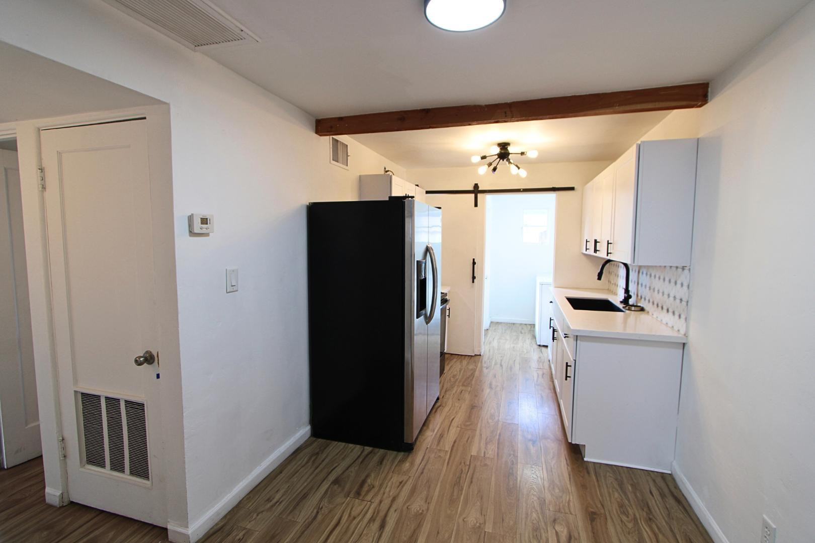 4212 North 19th Street, Unit A Phoenix, AZ 85016 - Photo 5 of 15 a kitchen with stainless steel appliances a refrigerator and wooden floor