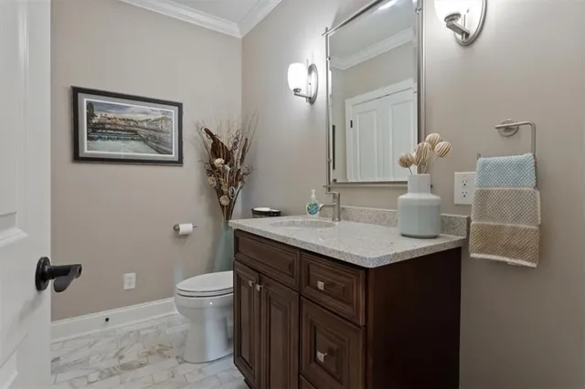 a front view of a house with a garden and lake view