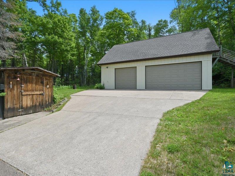 88440 Huron Street Cornucopia, WI 54827 - Photo 30 of 44 Heated three-car garage features a concrete slab and a 50-amp, 250-volt outlet—perfect for recreational equipment, hobbies, or additional storage.