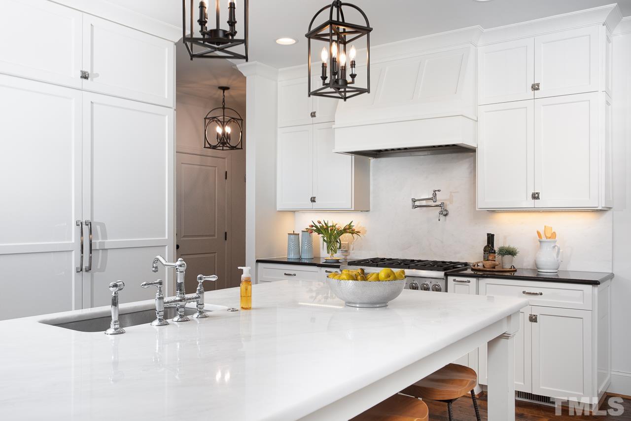 902 Shelley Road Raleigh, NC 27609 - Photo 12 of 45 a kitchen with stainless steel appliances a sink a stove and cabinets