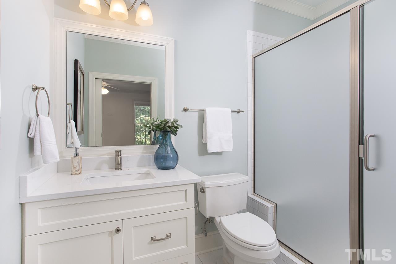 902 Shelley Road Raleigh, NC 27609 - Photo 18 of 45 a bathroom with a sink a toilet a mirror and shower