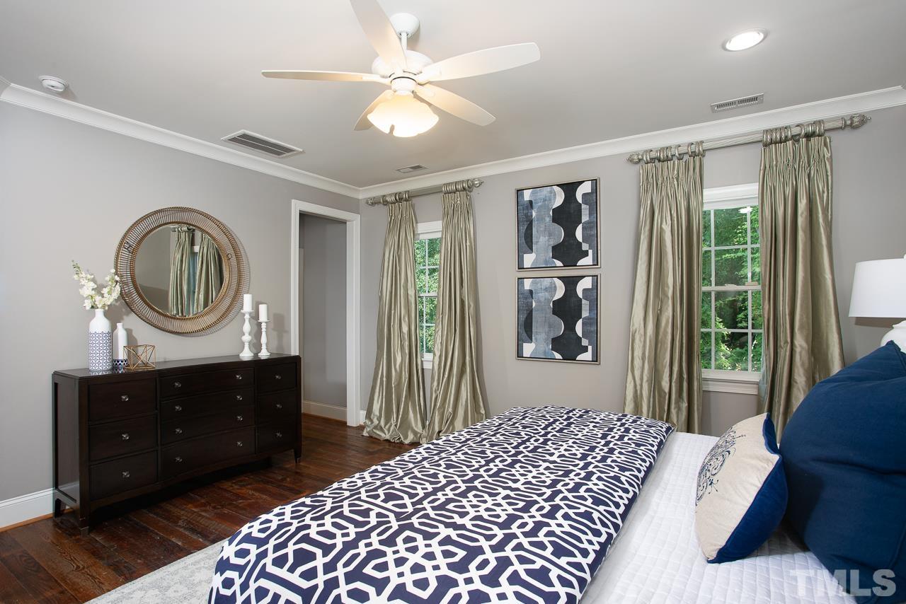 902 Shelley Road Raleigh, NC 27609 - Photo 23 of 45 a bedroom with a bed a mirror and a window