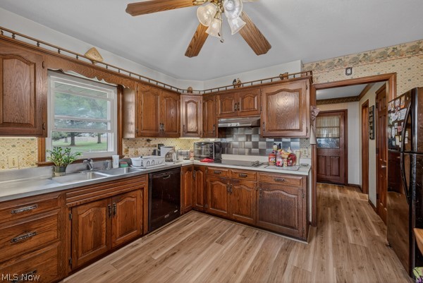 8675 West Smith Road Medina, OH 44256 - Photo 9 of 25 Kitchen featuring wood-finish cabinetry, light-toned countertops, and a double basin stainless steel sink beneath a window