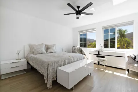 a bedroom with a large bed and a flat tv screen