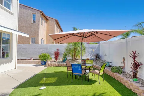 a view of a chair and tables in patio with a backyard