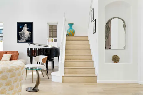a living room with furniture kitchen view and a large window