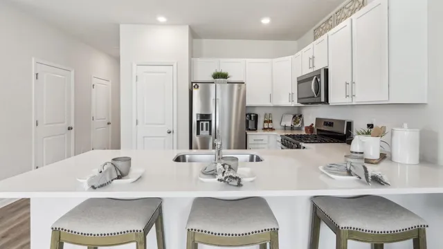 a kitchen with stainless steel appliances granite countertop a white table and chairs