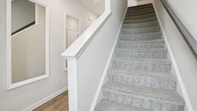 a view of staircase with white walls and white door