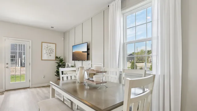 a dining room with wooden floor and a floor to ceiling window